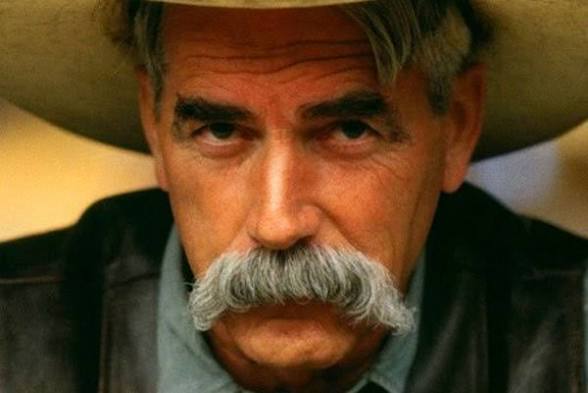 Close-up portrait of a man with a prominent mustache wearing a wide-brimmed hat.