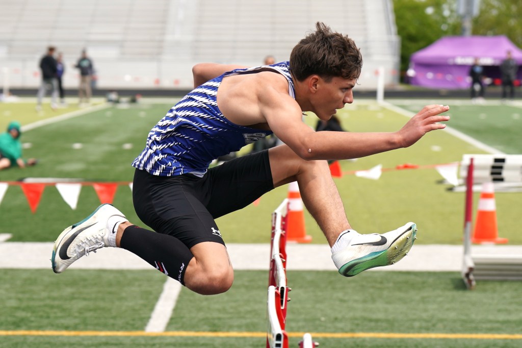 A male athlete performing a high jump over a hurdle during a track and field event.
