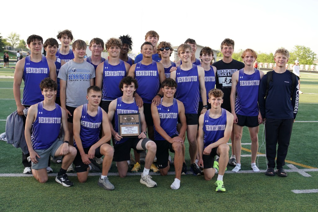 Group photo of the Bennington high school track and field team, posing together with a runner-up plaque after a district meet.