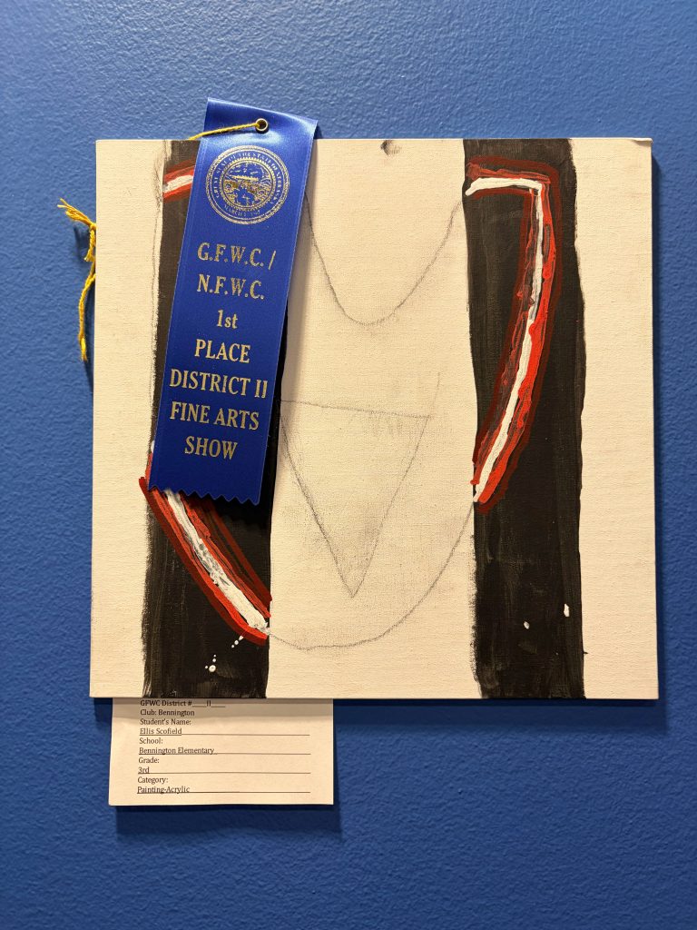 An acrylic painting displayed on a blue wall, featuring a 1st place ribbon from the G.F.W.C./N.F.W.C. District II Fine Arts Show. The artwork includes abstract shapes with red and black tones, and a label below detailing the artist's information.