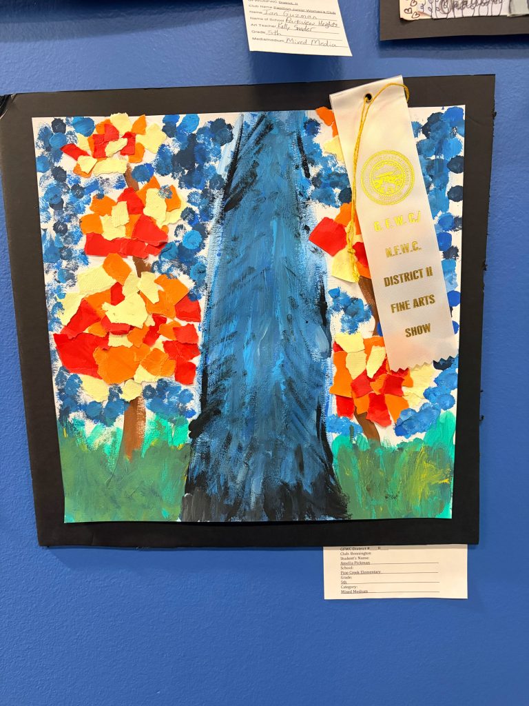 A colorful painting featuring a large blue tree in the center, surrounded by vibrant orange and red foliage, displayed at an art show with a ribbon indicating an award.
