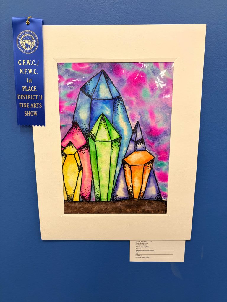 A colorful painting of various crystal shapes in vibrant hues, displayed in a white frame with a blue ribbon indicating first place in a fine arts show.