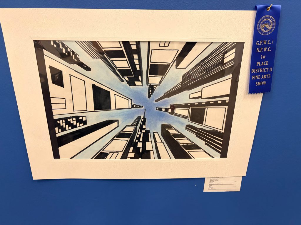 A vibrant artwork depicting a cityscape viewed from below, showcasing tall buildings reaching towards a blue sky. The piece is framed and includes a blue ribbon indicating first place in a district fine arts show.