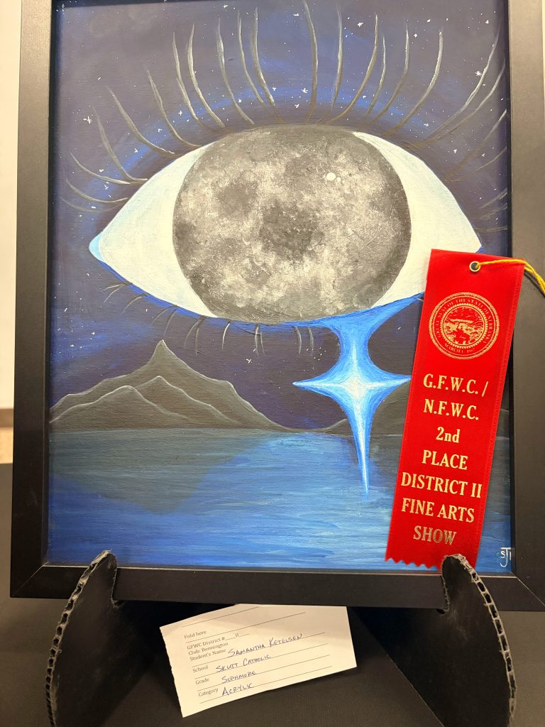 A framed painting featuring a large eye with a moon in the iris, surrounded by a starry night sky, mountains, and water below. A red ribbon indicating 2nd place in a fine arts show is attached to the frame.