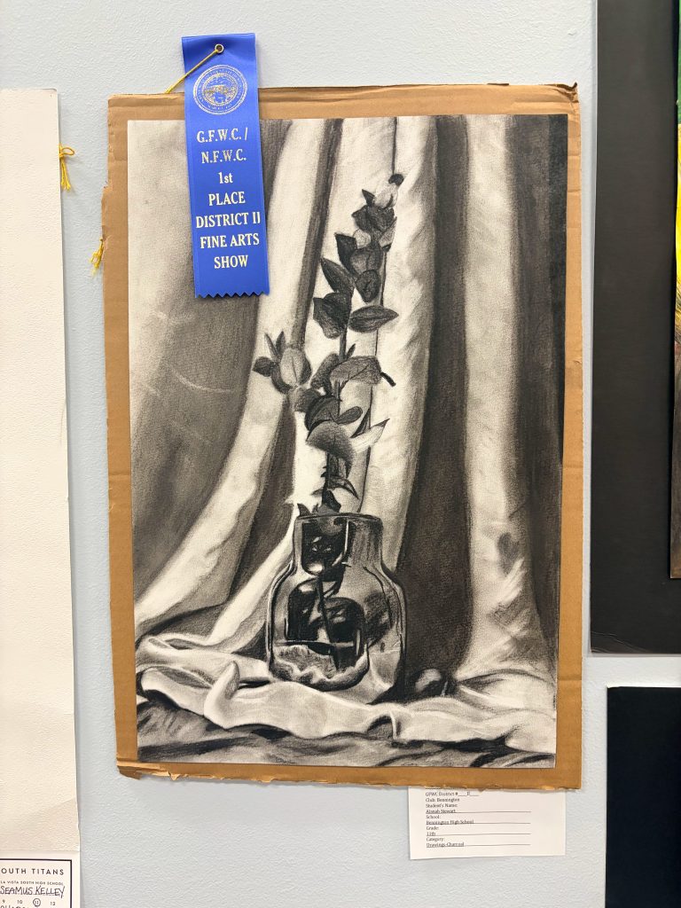 Black and white still life drawing of a vase with flowers, featuring a blue first place ribbon from the District II Fine Arts Show.