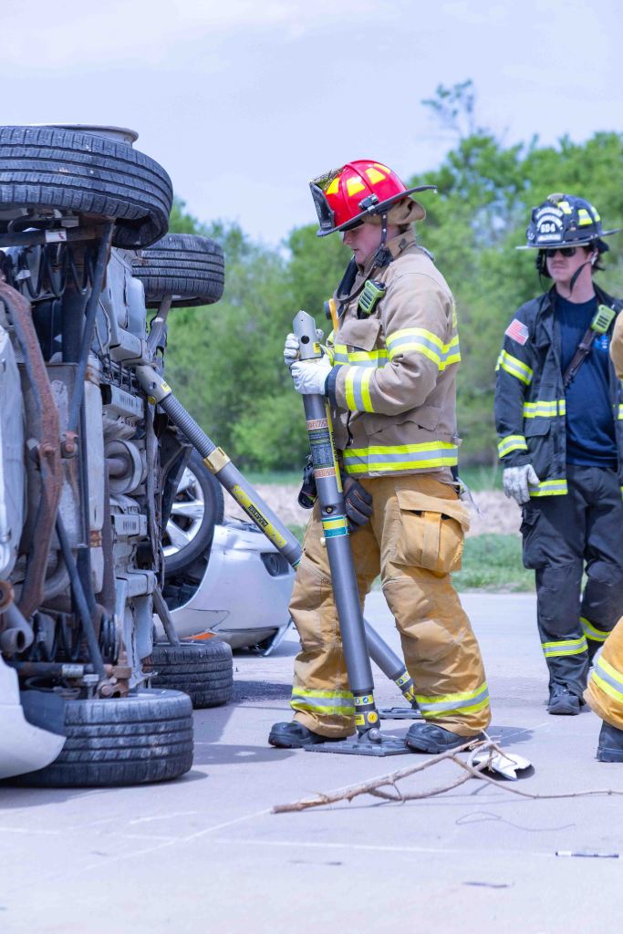 Firefighters responding to a vehicle rollover accident, using hydraulic rescue tools to assist in the emergency response.