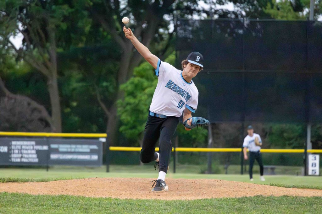 A baseball pitcher in mid-pitch throwing a baseball on a field.