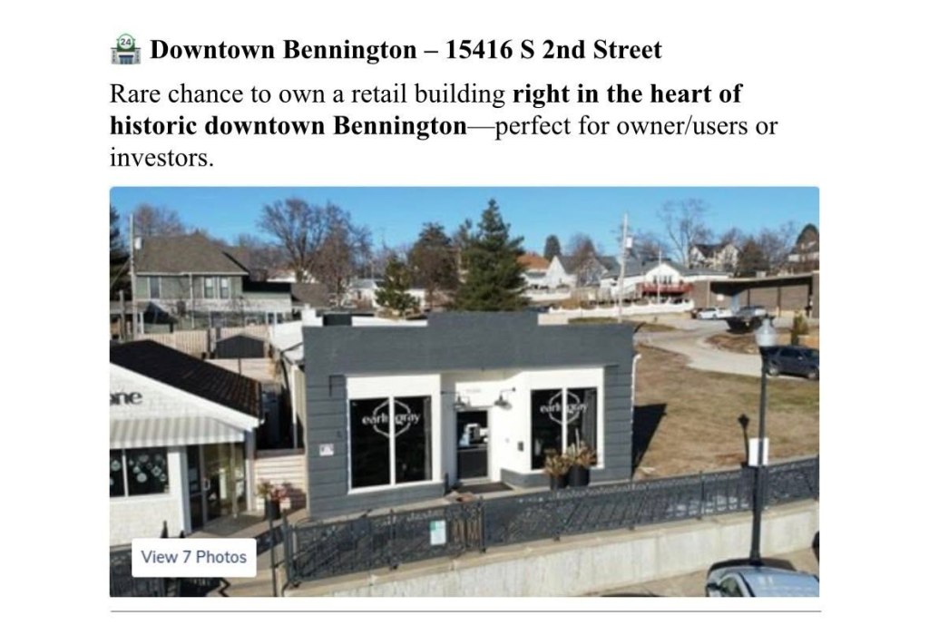 Aerial view of a retail building located in historic downtown Bennington, featuring a gray exterior and large windows, surrounded by trees and other buildings.