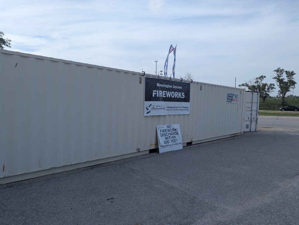 A storage container with a banner reading 'Bennington Jaycees Fireworks' and a warning sign stating 'No fireworks discharge within 300 feet.'