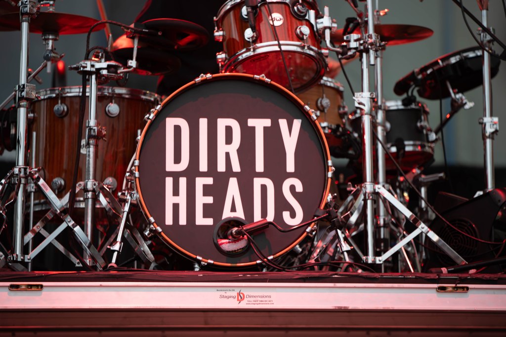 Close-up of a drum set featuring a bass drum with the text 'DIRTY HEADS' prominently displayed on the drumhead.
