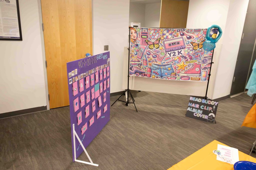 A colorful display featuring a Y2K-themed backdrop with retro items like cassette tapes and butterflies, alongside a purple guess-who game board from the 90s and 2000s.