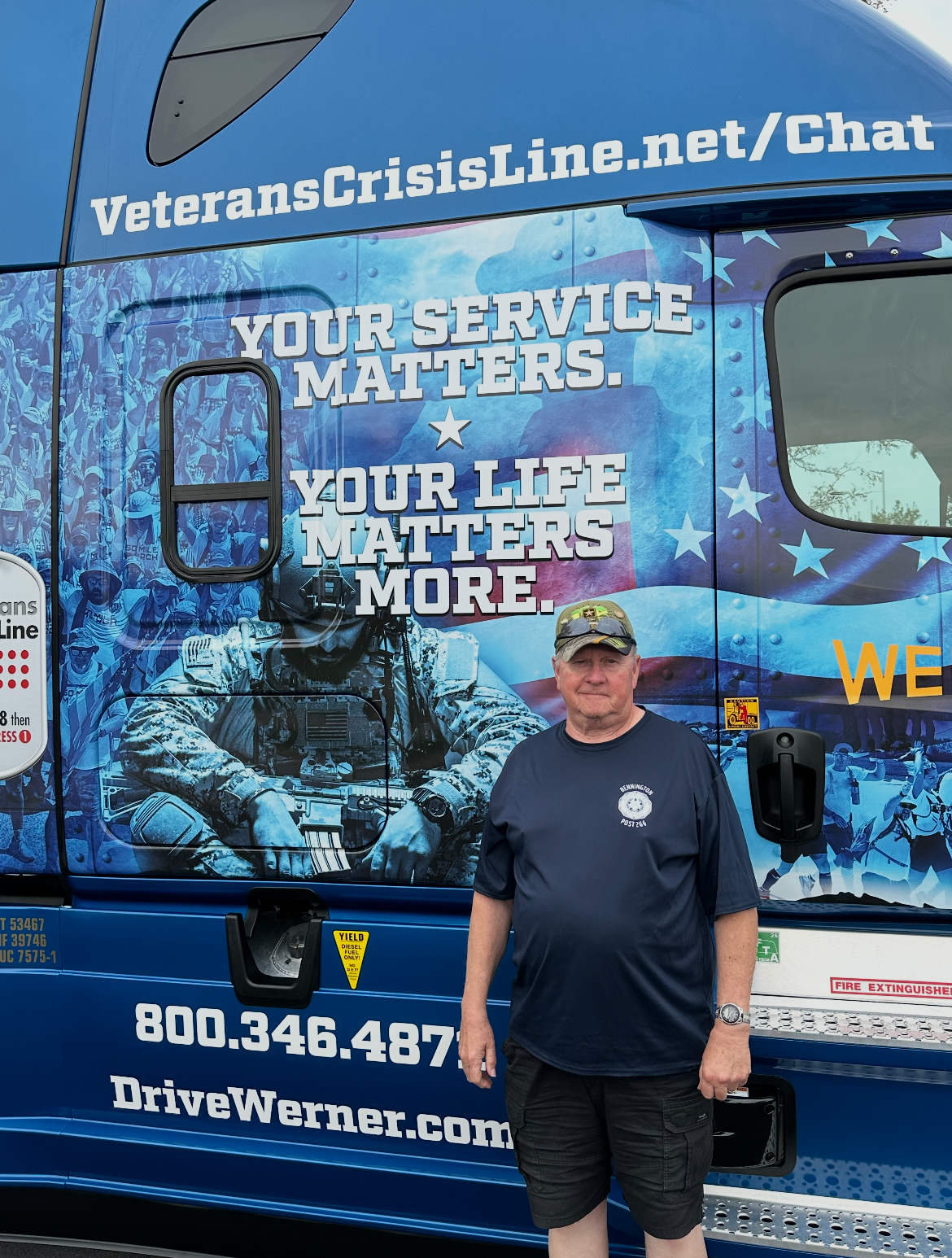 A man stands next to a truck decorated with a mural honoring veterans, featuring text that reads 'Your service matters. Your life matters more.'